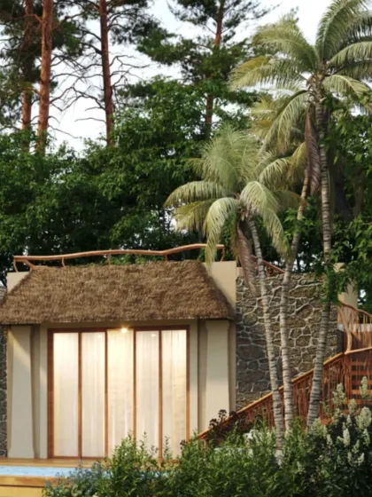 This view of a Dev Villa highlights the outdoor spiral staircase and lush landscaping. The design encourages an indoor-outdoor living experience, connecting guests directly with the natural environment.