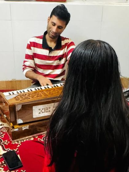A one-on-one moment during a Hindustani vocal lesson. Our coaches work closely with each student to refine their technique, ensuring they grasp the subtleties of their vocal training.