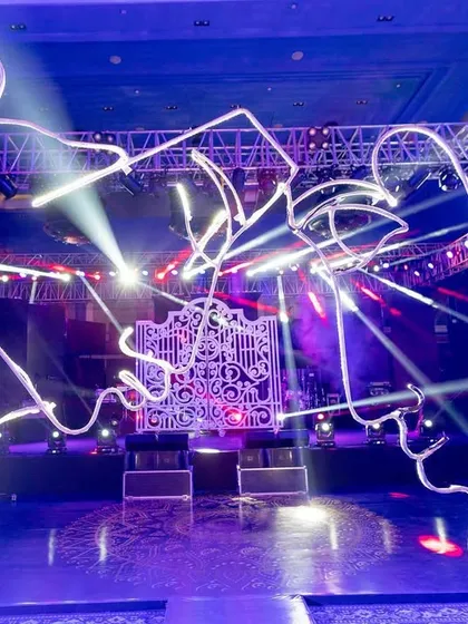 A unique neon light installation of two faces about to kiss, creating a modern and artistic focal point for a Sangeet or cocktail night.
