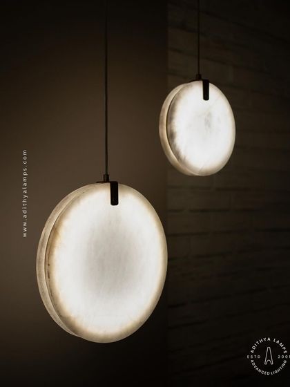 Showcasing our disc-shaped marble pendants. The light emanates softly through the thin slice of natural marble, revealing its unique veining. These fixtures are available in different shapes and look stunning hung in pairs or trios.