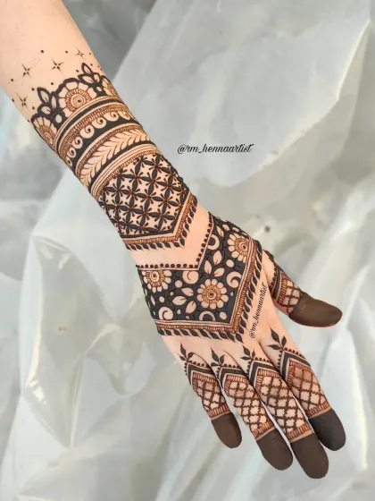 A beautiful and bold design for the back of the hand. I love how the geometric patterns and dark fingertips create a really striking and modern look.