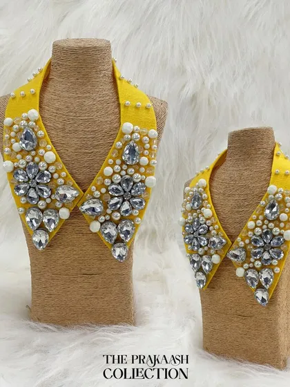Instantly transform any outfit with our detachable statement collars. This piece, shown in both adult and child sizes, features a vibrant yellow base adorned with large faceted crystals and delicate pearls for a truly glamorous look.