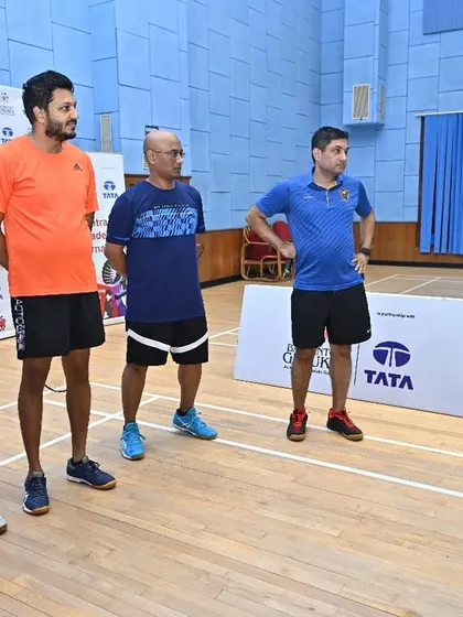 A coach briefs a group of adult players before their match. Our community events cater to both kids and adults, promoting fitness and fun for everyone.