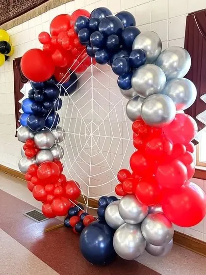 A Spider-Man inspired ring decoration. I used red, blue, and silver balloons to create the frame, with a spider web in the center to complete the superhero theme.
