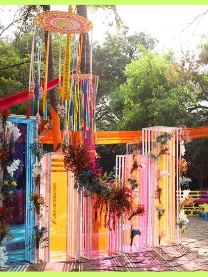 A vibrant and artistic photo backdrop. These colorful translucent panels are adorned with flowers, creating a unique and modern look for a daytime event.