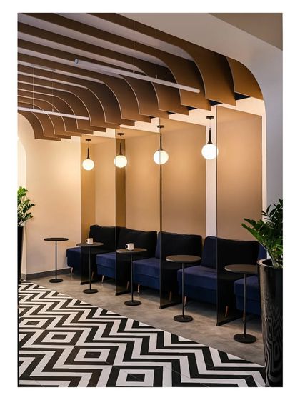 We created these informal working nooks to provide employees with a dynamic zone away from their desks. The cozy blue seating, individual tables, and pendant lighting offer a comfortable space for breaks or collaborative chats.