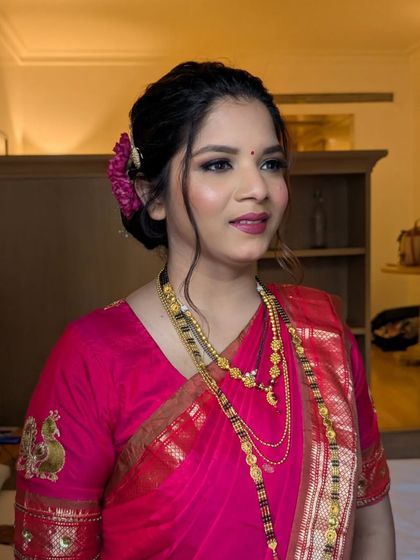 A classic party look for a Maharashtrian event. The pink saree is paired with a soft glam makeup look and a traditional floral bun.
