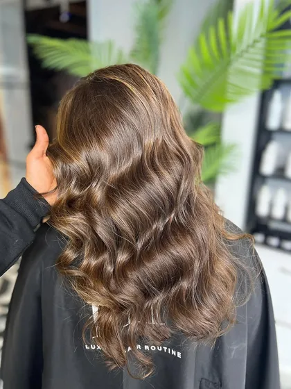A closer look at a beautiful balayage, showing the seamless blend of colors and the healthy shine of the hair.