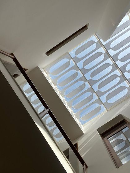 The intricate patterns created by a decorative skylight grill, viewed from below. This feature turns the ceiling into a canvas for light, casting beautiful, artistic shadows.