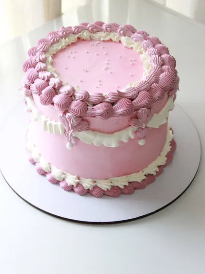 A beautiful pink Lambeth-style cake with detailed, over-the-top piping for a romantic, vintage feel.