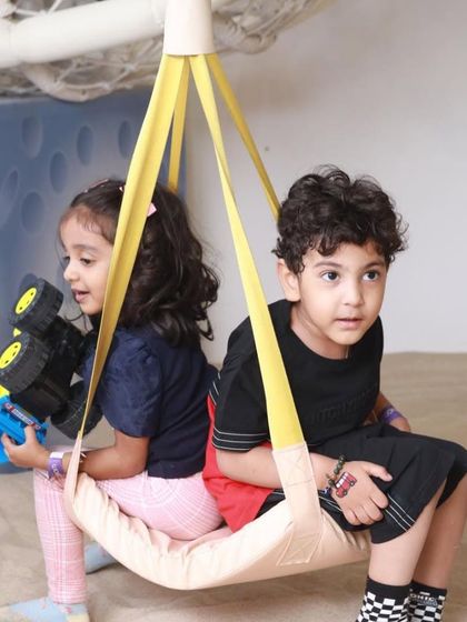 A quiet moment on the swing. Our play area has a mix of high-energy zones and calmer spots for kids to relax and play.