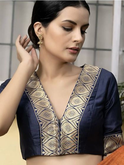 A closer look at this navy blue silk blouse with a stunning brocade border. The deep V-neck and elbow-length sleeves offer a perfect blend of traditional grace and contemporary style.