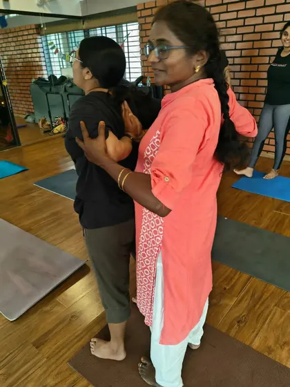 Helping students find the correct arm position in Gomukhasana (Cow Face Pose). This partner assist helps to gently open up tight shoulders.