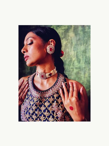 A detailed shot of a navy blue embroidered blouse paired with a ruby and polki choker set. This demonstrates how I style complementary colors and textures for a rich, layered effect.