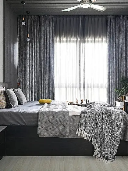 This bedroom showcases the power of a monochrome palette. We layered various shades and textures of grey, from the concrete-finish wall and fluted panels to the soft furnishings, creating a sophisticated and calming atmosphere that remains visually interesting.