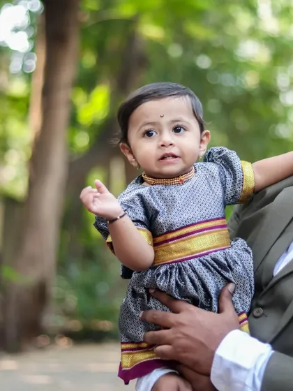 A close-up shot of the baby from a family session, dressed in a traditional Maharashtrian parkar polka. I pay attention to these details that make your family's photos unique.