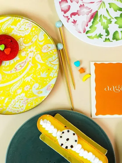 A flatlay of colorful, patterned plates with various pastries, demonstrating creative tableware styling.