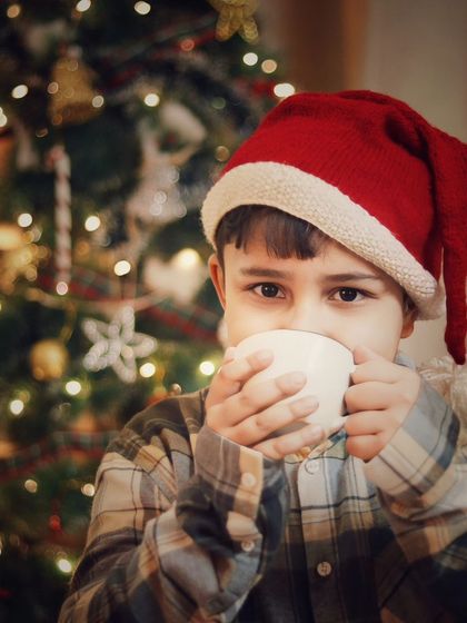 A cozy moment with a warm cup of cocoa by the Christmas tree. This photo captures the comforting and peaceful feeling of the holiday season.