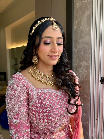 Pink glam for this sangeet look, with a focus on shimmery pink eyeshadow and voluminous curls.