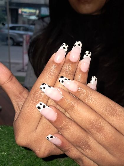 A playful cow print French manicure. This fun design on long coffin nails is a great way to show off your personality while still having a classic French tip base.