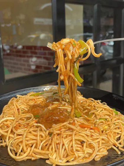 A forkful of my Manchurian Noodles with Gravy, showing the perfect combination of noodles and Manchurian balls.