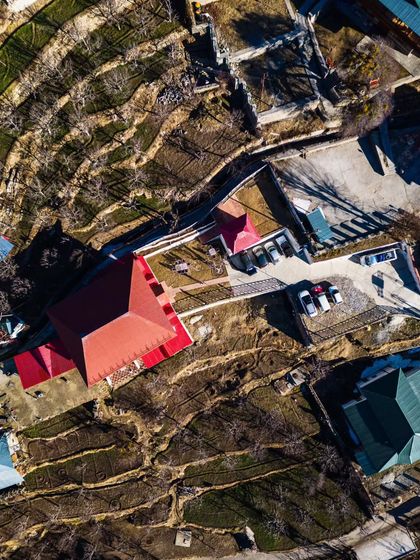 An abstract top-down view of a village in Spiti, showing the geometric patterns of rooftops and terraced farms.