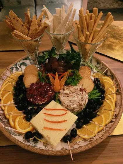 Feast your eyes on this charcuterie board! A snack-tastic masterpiece of cheeses, crackers, breadsticks, fruits, and olives, perfect for any gathering.