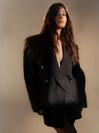 A powerful portrait using a single light source to create a dramatic sliver of light on the model's face and body. The rest of the image falls into deep shadow, creating a moody and high-fashion feel.