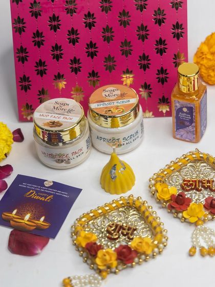 A luxurious Diwali hamper featuring my handmade skincare products. This set includes a Mud Face Pack, Apricot Scrub, and Abhyanga oil, paired with decorative 'Shubh Labh' hangings and a modak candle.