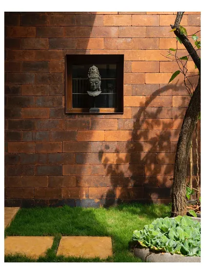 We let materials speak for themselves. The warm, earthy texture of these bricks from Bali, combined with the dappled sunlight filtering through the trees, creates a facade that feels both timeless and alive.