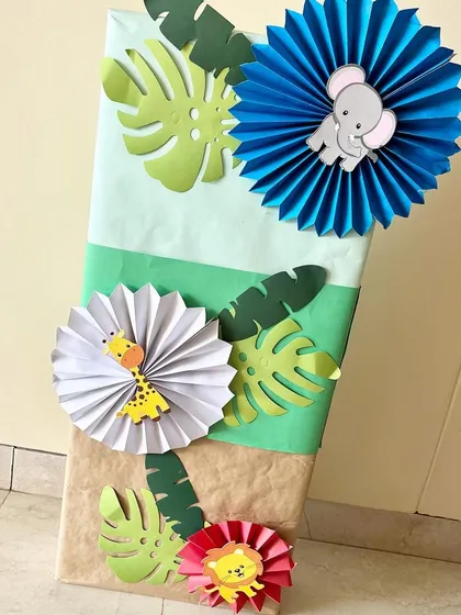 Themed gift wrapping for the baby shower, using jungle-inspired paper cutouts and embellishments.