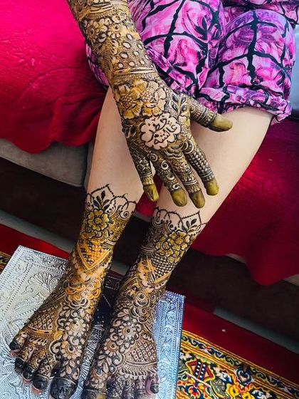 A stunning view of a complete bridal henna set after the paste has been removed. The rich, dark stain is clearly visible on both the hands and feet.