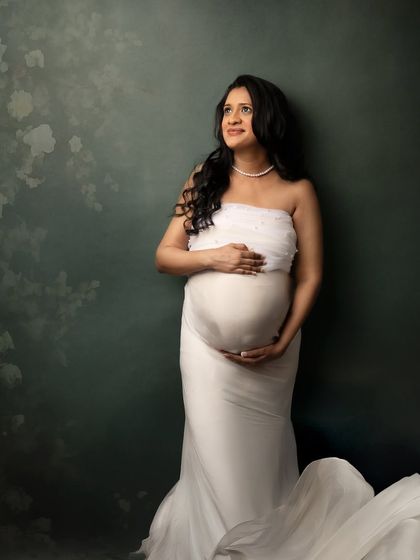 A serene moment in white. Leaning against a textured backdrop, this pose feels thoughtful and peaceful.