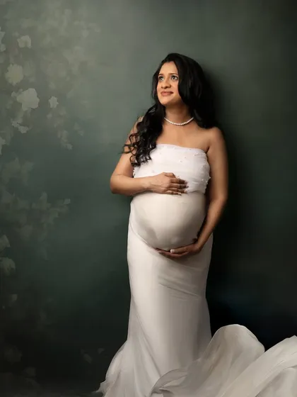 A serene moment in white. Leaning against a textured backdrop, this pose feels thoughtful and peaceful.