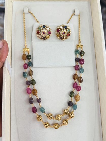 This colorful beaded necklace set features a variety of semi-precious stones, making it a vibrant and unique accessory. The matching multi-color studs complete the look.