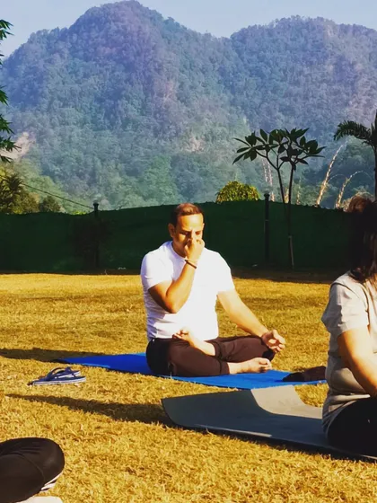 A student practices Nadi Shodhana (Alternate Nostril Breathing) during our yoga retreat in Rishikesh. The serene mountain environment enhances the calming effects of pranayama.