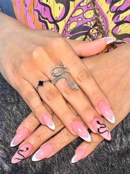 For a look that's a little more edgy, I created this snake-themed nail art. It combines a classic white French tip with a detailed, hand-painted black snake that winds its way across two accent nails.