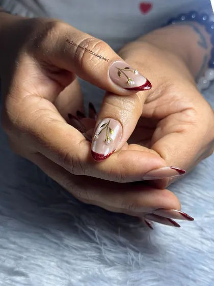 My most favorite nail set. A beautiful cat eye base with a deep red glitter French tip and delicate cherry blossom accents.