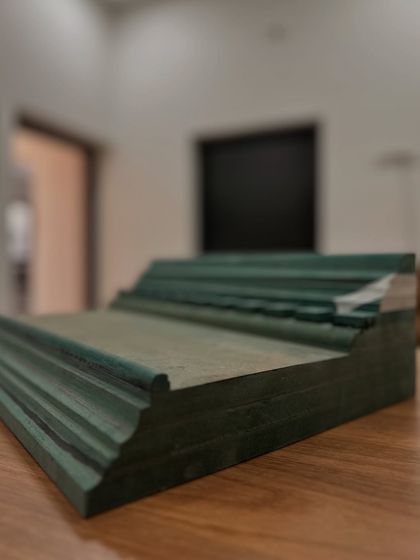 A sample of the custom-molded MDF cornice before installation. We designed the profile to be bold and structural, providing the perfect base for the decorative wallpaper border that would ultimately give it a unique, layered finish.