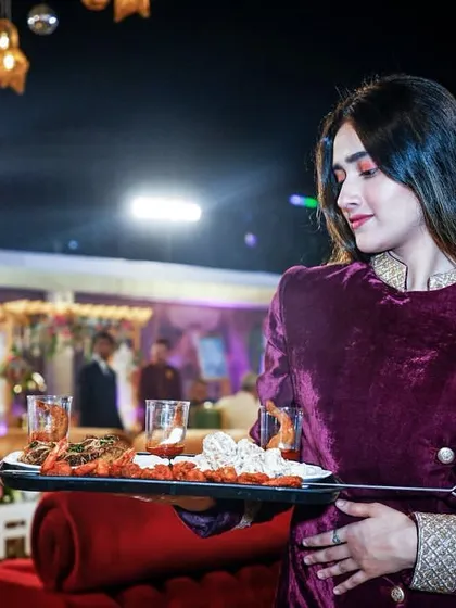 Service with elegance. A staff member carries a tray of appetizers through a beautifully decorated event space.