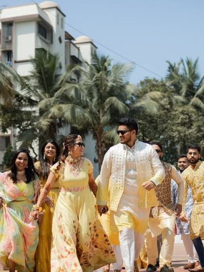 The bride and groom leading their energetic friends and family in a fun procession. A snapshot of collective joy and celebration.