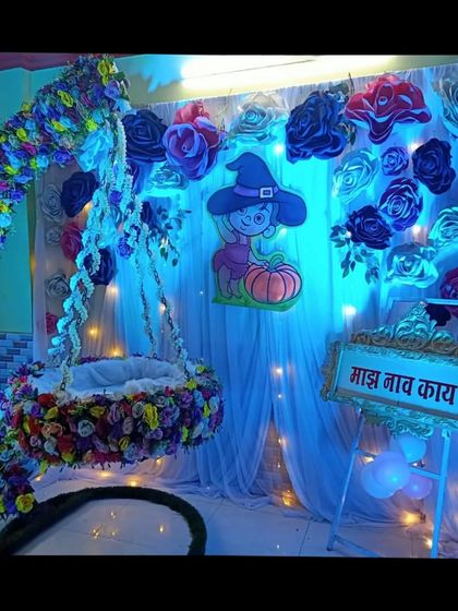 A Halloween-inspired naming ceremony theme with a floral moon cradle and a cute witch cutout. The sign asks, "Majha Nav Kay?" (What's my name?).