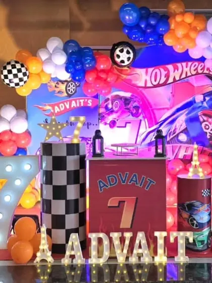 A powerful Hot Wheels themed 7th birthday party with large car cutouts and a fiery color palette.
