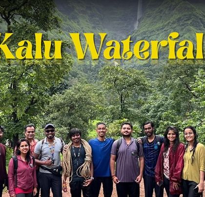 A smaller group posing for a picture with the majestic Kalu Waterfall in the background.
