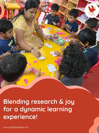 We blend research and joy for a dynamic learning experience. Here, a teacher guides a group of children in a hands-on craft activity, fostering creativity and fine motor skills.