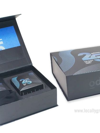 This premium gift box for Odessa celebrates their 25th anniversary. The elegant black box with silver and blue branding opens to reveal a custom-designed interior, perfect for housing commemorative gifts.