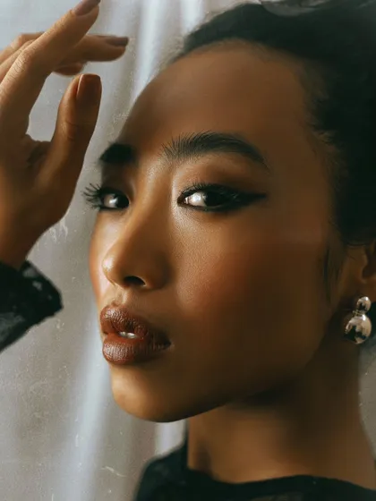A beautiful, light-filled close-up. The sliver of light across the model's face highlights her features and creates a dreamy, ethereal quality.