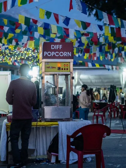 Sometimes the small details tell the biggest story. This candid shot of a popcorn stand under festival flags at DIFF helps build a complete picture of the event experience.