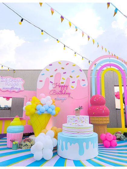 The full party scene, including a pink ice cream truck prop, the cake display, and a large light-up number '3'.