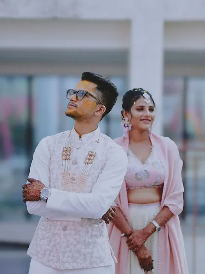 A stylish shot of the groom looking up, with his bride standing beside him.